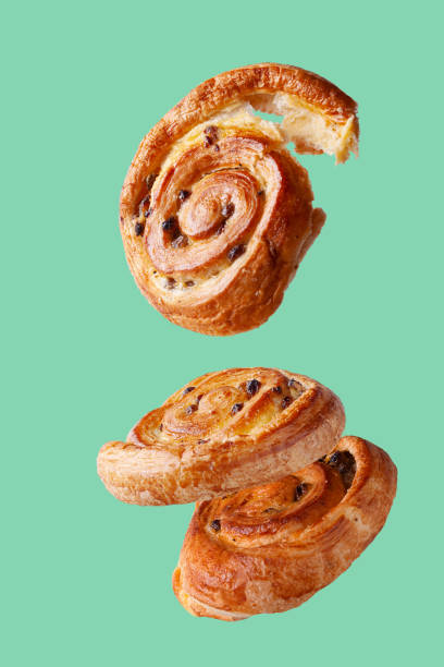 istock buns with raisins flying food selective focus on green background 1350674526