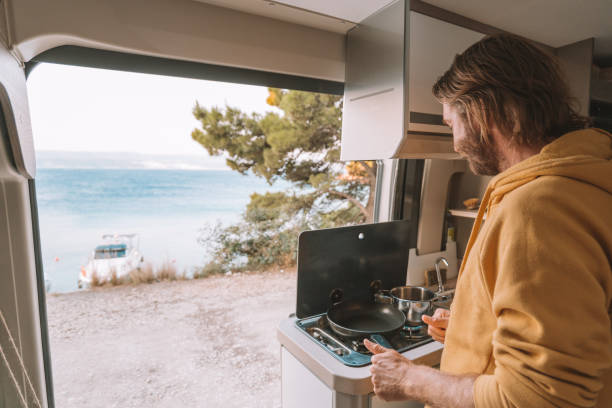 istock Man prepares breakfast in his van, sea view 1350675429
