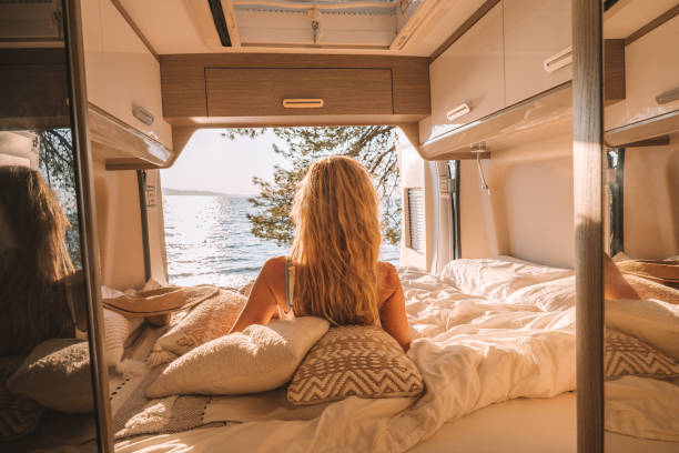 istock Woman in her van looking at ocean 1350675741