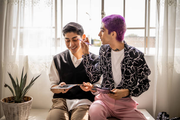 Gay friends putting make up on stock photo
