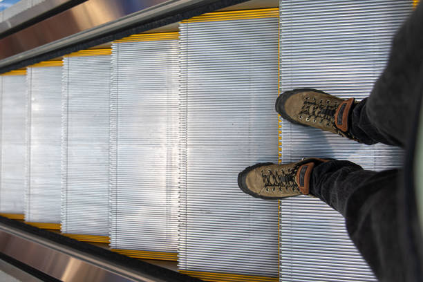 istock Male feet on the escalator, top view. 1350681512