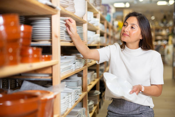 istock Young woman choosing new dishware at store 1350681574