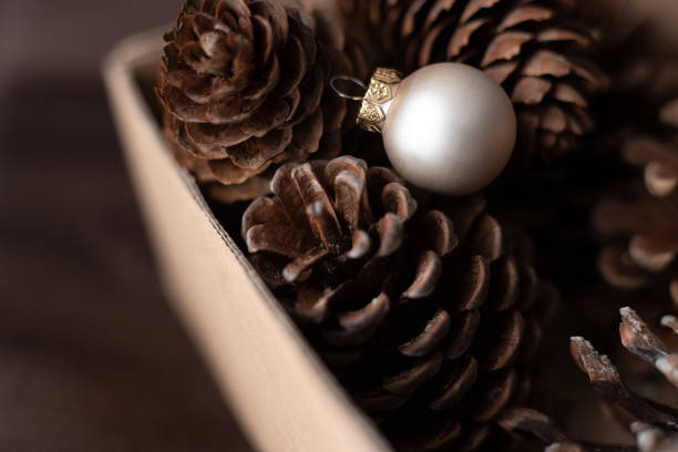 Pine cones in the box with silver Christmas bauble.