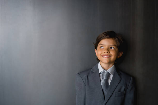 Thoughtful boy thinking as business man Portrait of a thoughtful Latin American boy thinking as business man and smiling ring bearer stock pictures, royalty-free photos & images