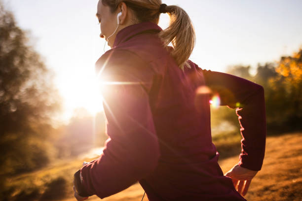 istock Beautiful woman jogging  against sun 1350687190