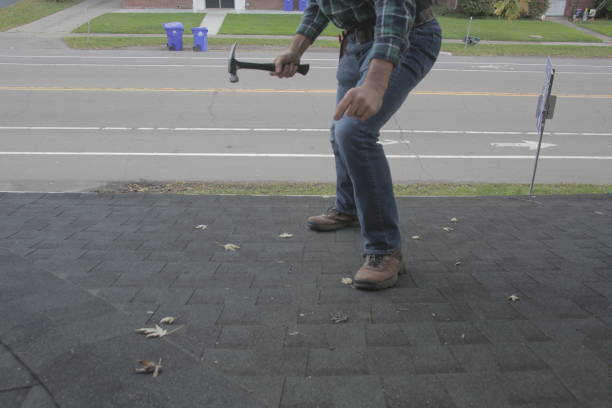 istock Roofer standing on residential rood with hammer 1350689211