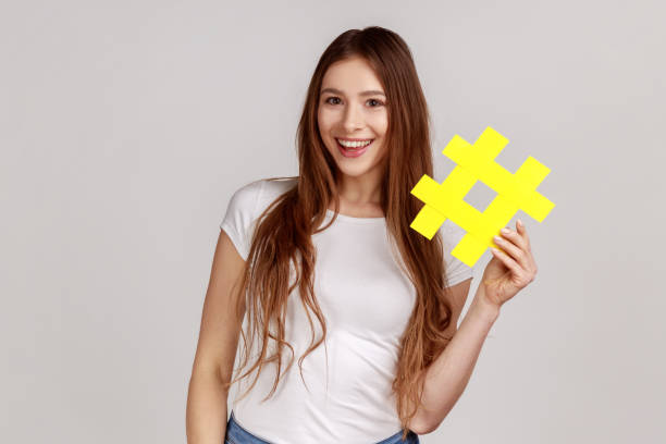istock Woman holding yellow hashtag symbol, making important topic popular, setting trends on Internet. 1350691464