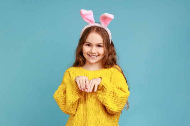 小さな女の子の肖像画は、ピンクのバニーの耳で立って、ゲームを楽しんで子供は、カメラを見ます。 - easter easter bunny fun humor ストックフォトと画像