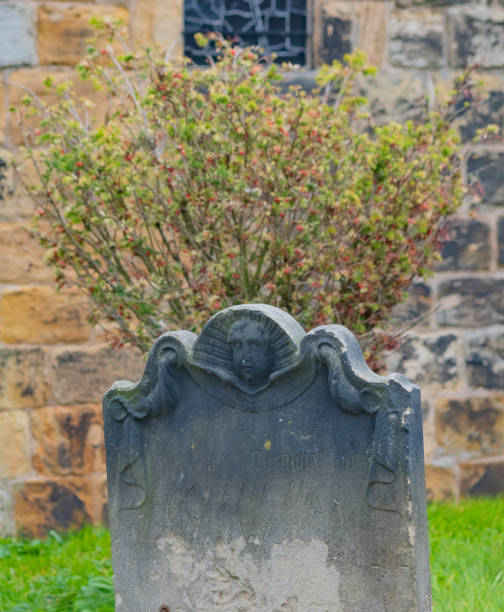 istock Ancient and ornate headstone in a graveyard 1350692401