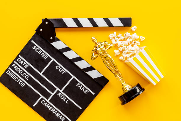 istock Golden film award statue with clapper board and popcorn 1350694164