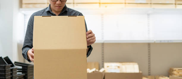 istock Asian man opening cardboard box lid 1350695675