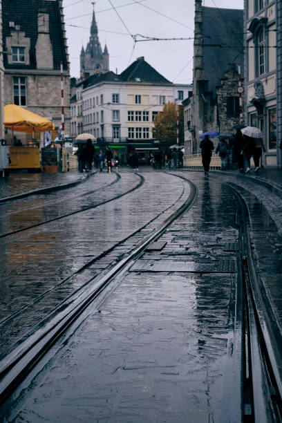 Ghent, Belgium - October 30, 2021: People walk outdoors on a rainy day in Ghent