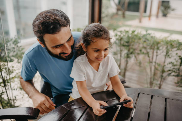 istock father and daughter interacting with cell phone 1350699665