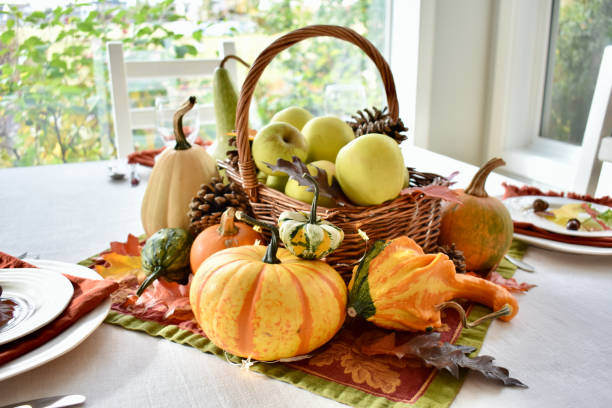 fall harvest dinner table decorative centrepiece with autumn squash, pumpkins and apples - pronkstuk stockfoto's en -beelden