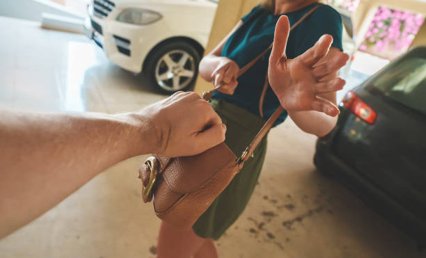 Thief snatches a bag from a woman in the parking lot. Thief snatches a bag from a woman in the parking lot. pickpocketing stock pictures, royalty-free photos & images