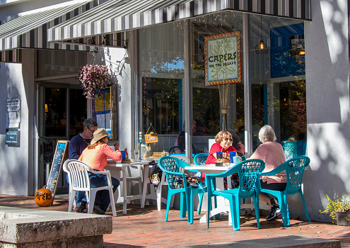 Dahlonega, Georgia - October 26, 2021: Dining alfresco on a warm autumn afternoon on the sidewalk in front of Capers, one of the several eateries on the historic public square.