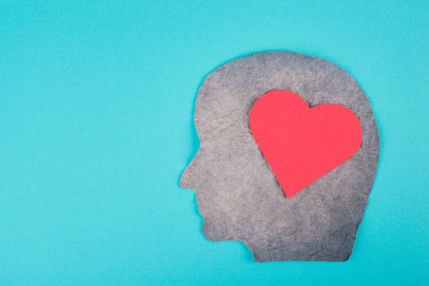 istock Silhouette of a face with a red colored heart, scrambled paper, blue background, copy space, emotion symbol love 1350711577