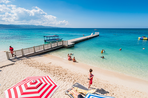 People enjoy Doctor's Cave Beach in Montego Bay Jamaica on a sunny day.