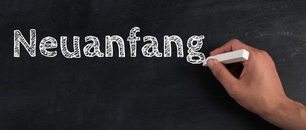 istock The words new start are standing on a chalkboard, hand writing, german language 1350711690