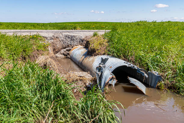 Road and culvert damage due to flooding and water erosion. Road repair, infrastructure and erosion control concept stock photo