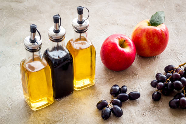 sidra de manzana y vinagre balsámico en botellas con uvas y manzanas rojas - balsamic vinegar bottle vinegar red wine fotografías e imágenes de stock