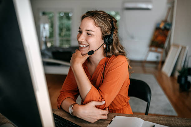 istock Cheerful young woman video conferencing on computer at home office 1350717653