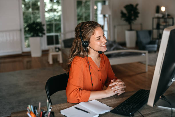 istock Cheerful young woman video conferencing on computer at home office 1350717786