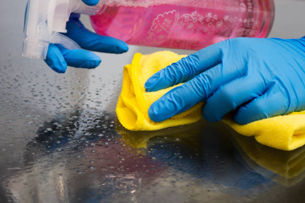 istock Cleaning home table surface with disinfectant spray bottle . 1350721097