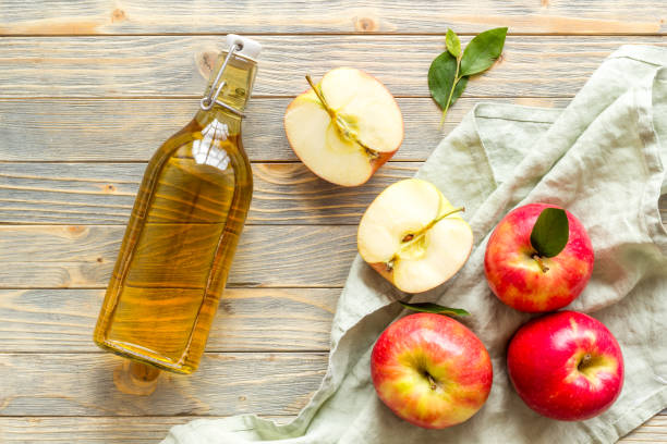 istock Bottle of organic apple cider vinegar with red apples 1350723847