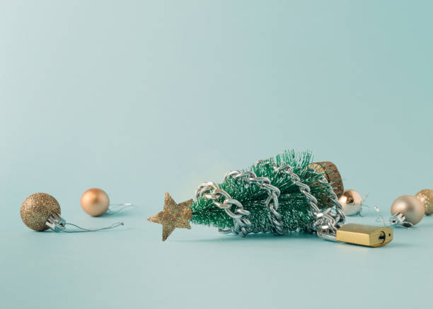 istock Layout with a Christmas tree with chain and padlock and Christmas balls on blue background. New Year mood in covid time. 1350724025