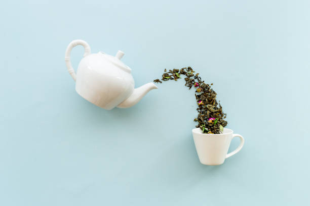istock Tea background o white teapot and cup with dry tea leaves 1350727175