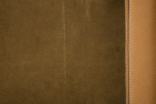 Combined background of brown suede and saffiano real or genuine leather stitched with seams.