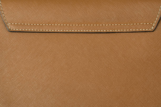 Brown saffiano leather stitched with a seam. Real or genuine leather texture background.