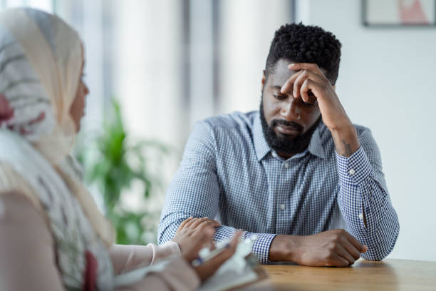 feeling depressed during a therapy session - behavior office men sadness imagens e fotografias de stock