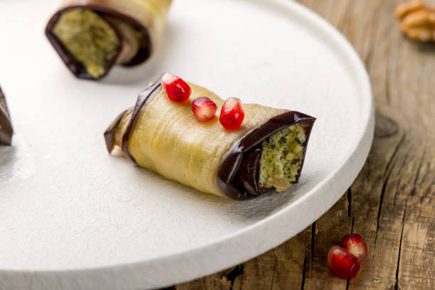 istock Eggplant rolls stuffed with nuts on white plate, georgian cuisine on wooden table 1350733877