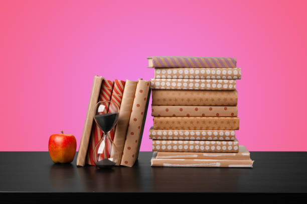 istock Education concept with stack of books on a table against colored background. 1350744396