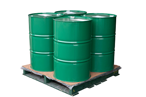 Group of green color metal barrels on pallet isolated on white