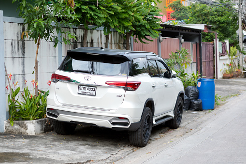 Back of white colored Toyota Fortuner SUV parked in street of Bangkok