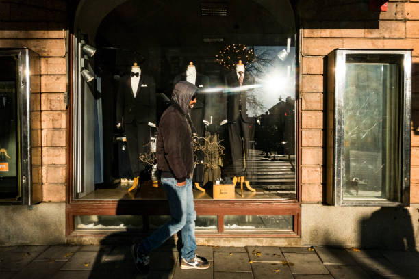 Stockholm, Sweden, Oct 24, 2021 A pedestrian walking by a men's clothing store on Odengatan.