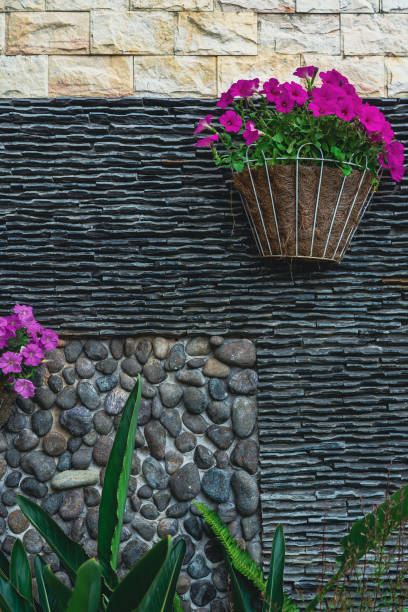 istock Wall decorated with stones and flowers 1350757680