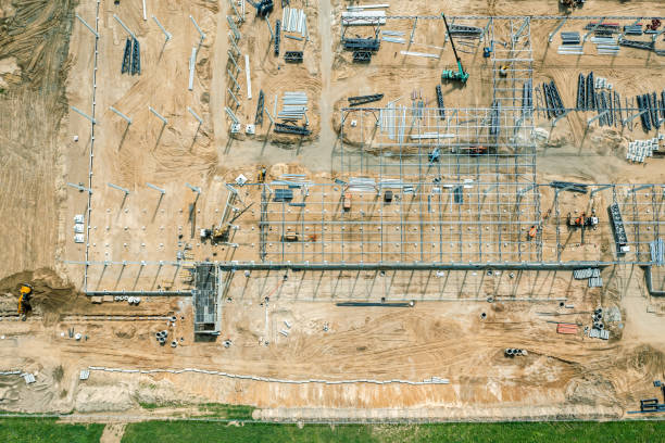 istock steel frame construction of modern hangar or factory. construction site with building materials and working machinery. aerial drone photo. 1350759536