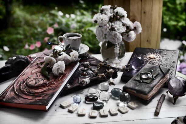 istock Grunge still life with old book of spells, runes and witch magic objects on ritual table. 1350759550