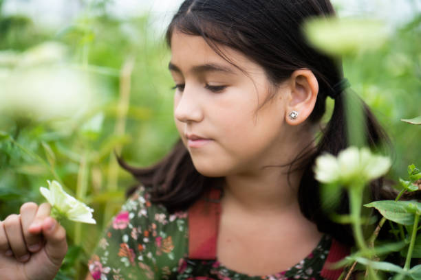 retrato de menina hispânica em um campo de flores - child little girls single flower flower - fotografias e filmes do acervo