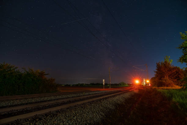 Milkyway with its galactical centre over a lonely railway track standing over the stop train signal at a starry night. Milkyway with its galactical centre over a lonely railway track standing over the stop train signal at a starry night railway signal stock pictures, royalty-free photos & images