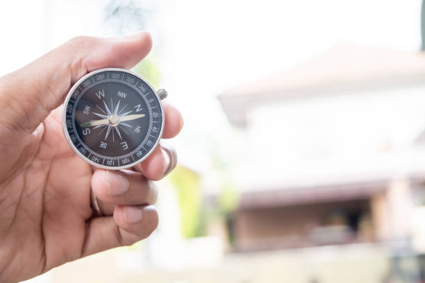 istock Man hand holding compass on city and car blurred background Using wallpaper or background travel or navigator image. 1350765014