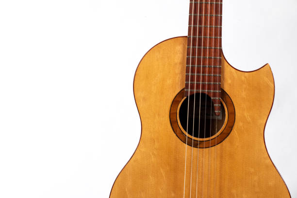 An overhead view of a well worn and played wooden classical acoustic guitar.  Vertical image.