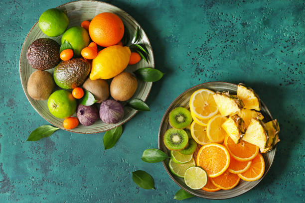 istock Plates with various delicious exotic fruits on color table 1350765811
