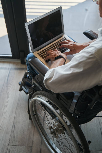 istock Person with disability using laptop from wheelchair 1350766064