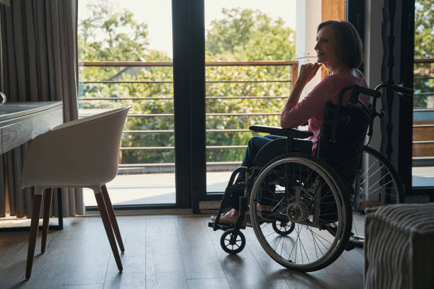 istock Pleased female wheelchair user looking inside a house 1350766070
