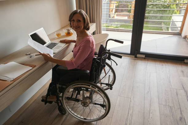 istock Disabled lady smiling to camera from desk with laptop 1350766077